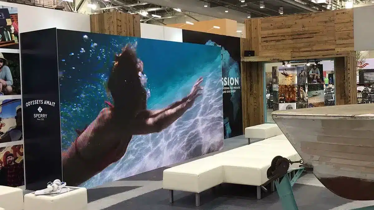 Exhibit booth featuring a vibrant underwater LED display, modern seating, and rustic wooden accents