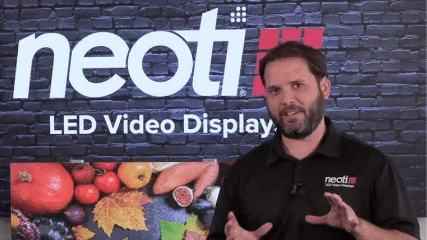 Neoti technician in front of an LED video wall display