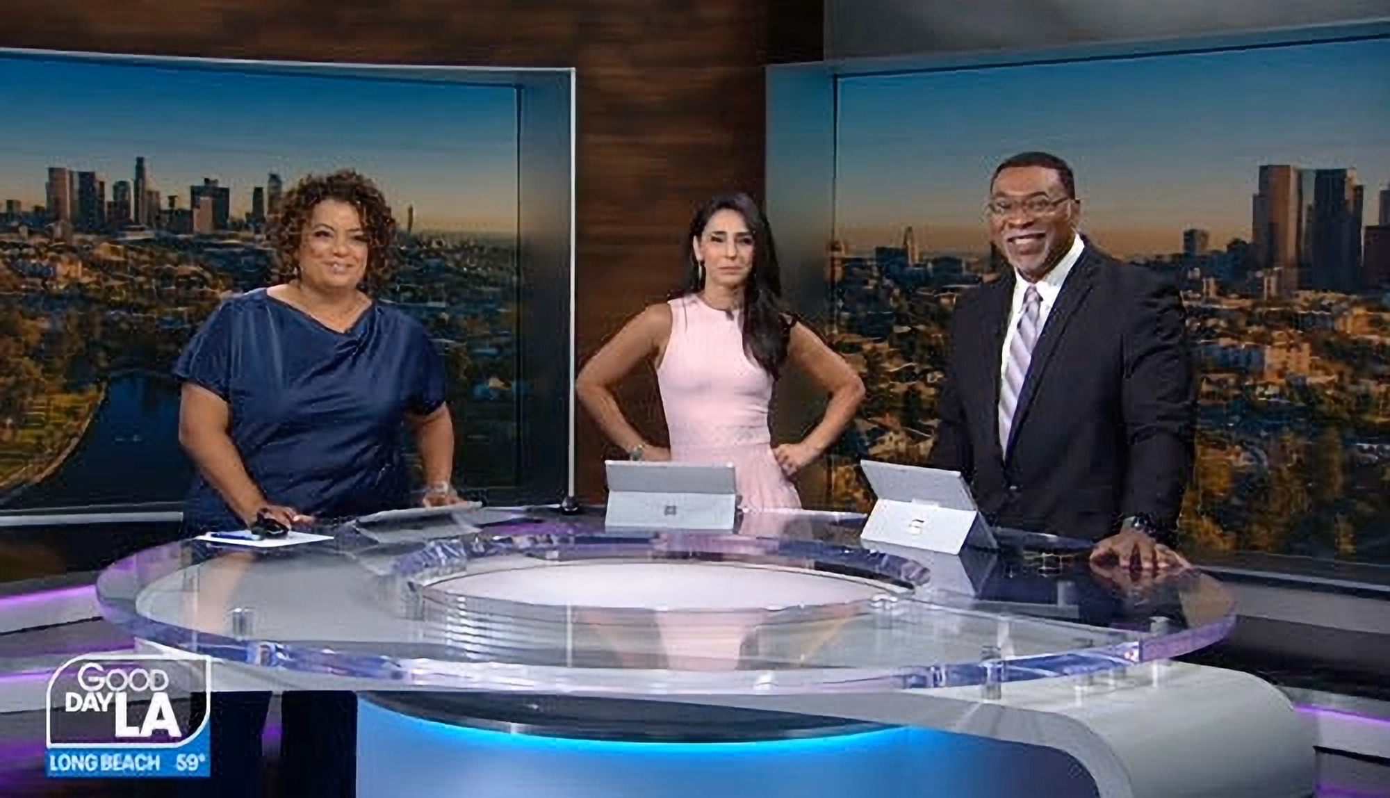 TV news anchors posing for a photo in front of their new LED video walls.